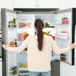 Best temperature for fridge - woman opening refrigerator door