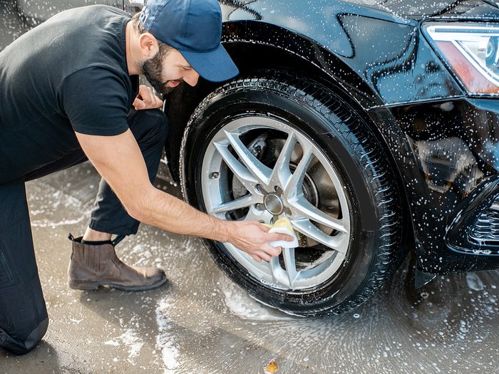 Car washing tips from pros - man washing car tires
