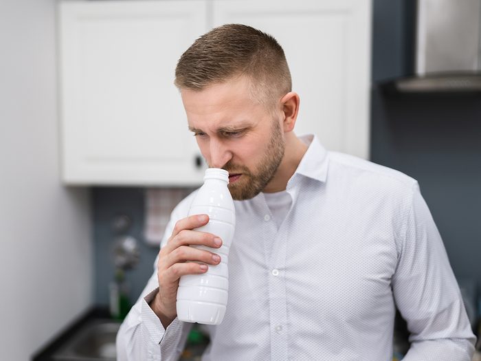How to avoid food poisoning - man sniffing milk
