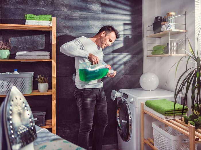 Laundry tips - man pouring laundry detergent