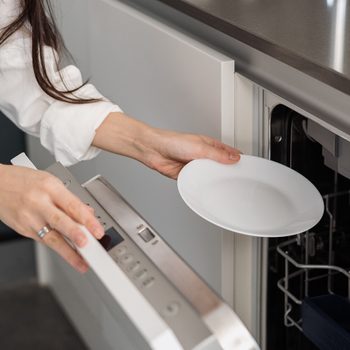 Woman using dishwasher