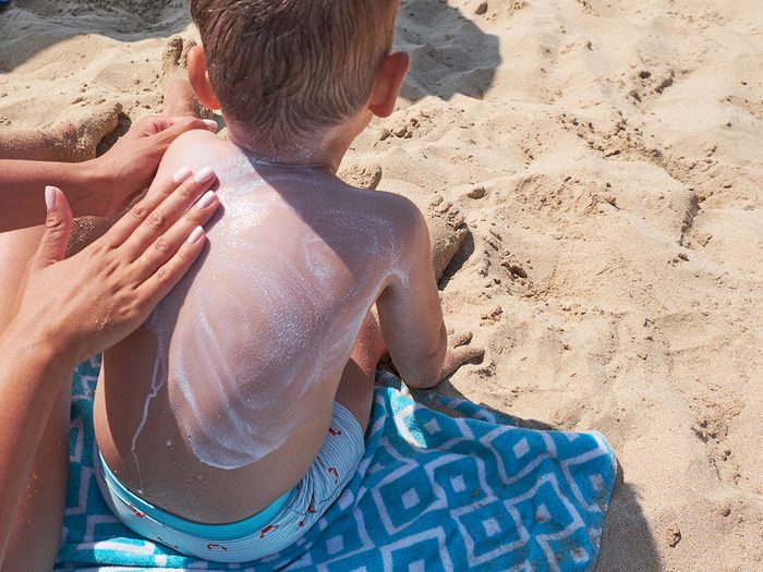 Applying sunscreen on child's back