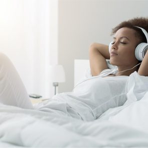 Mental health podcasts - woman in bed listening