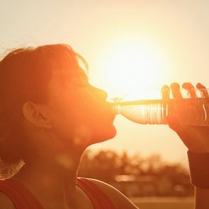 Summer heat - woman in full sun drinking water