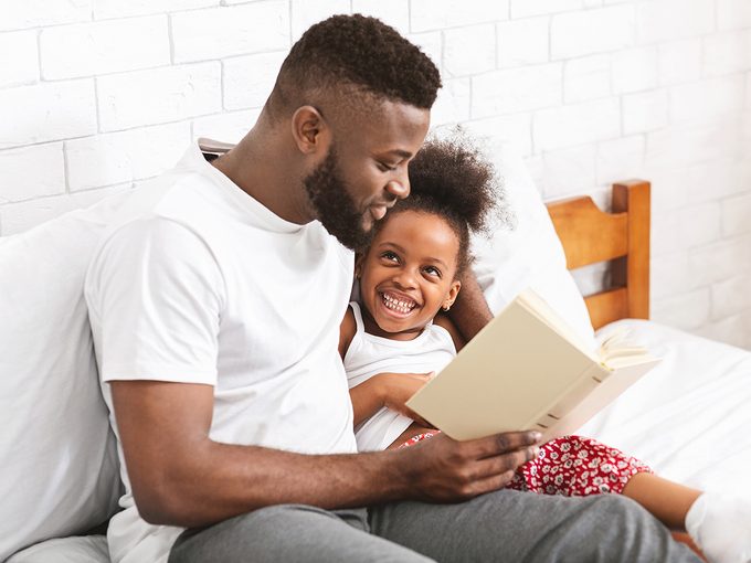 Reading out loud - man reading to young daughter