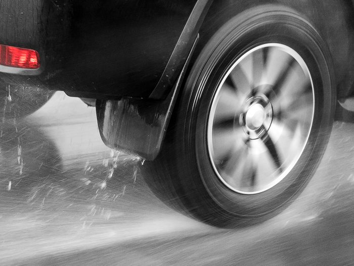 Summer driving hazards - car tire hydroplaning on wet road