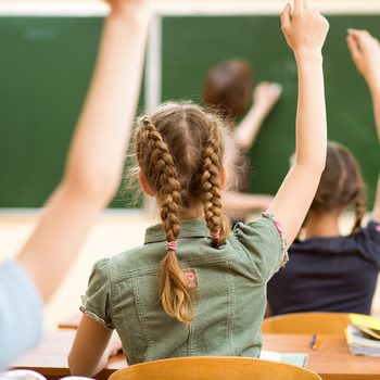Kids raising hands in class