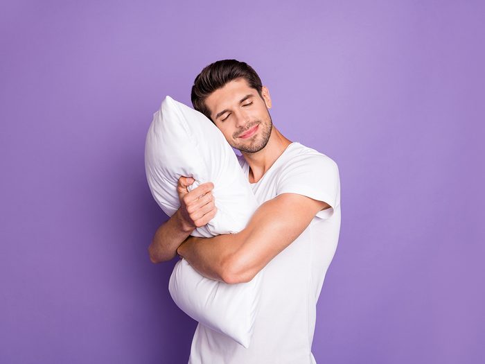 Man hugging pillow