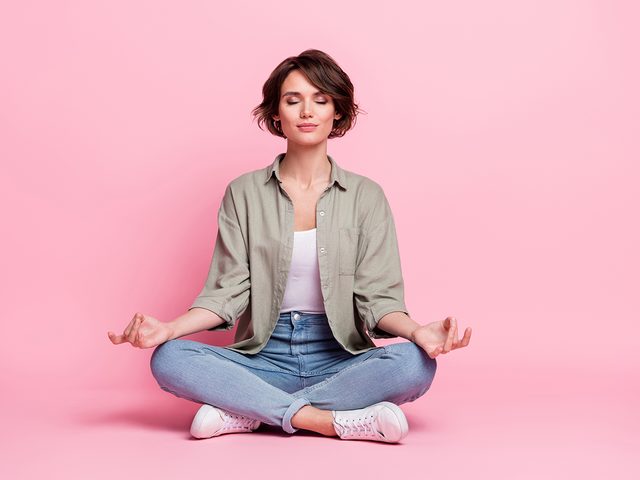 Woman meditating on pink