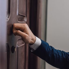 Door-to-door salesman knocking on door