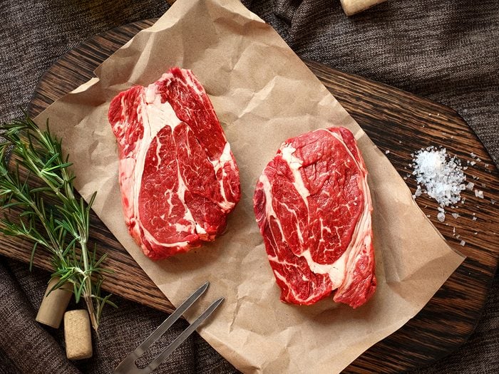 Raw steaks on cutting board