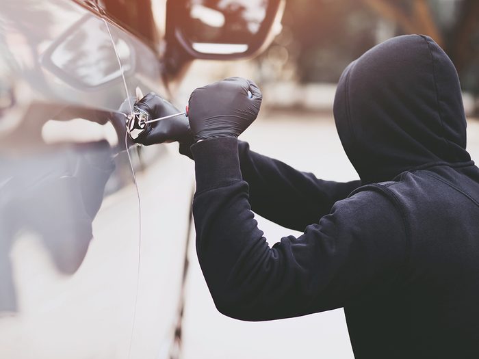 Car security - car thief tampering with car door lock
