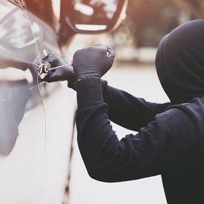Car security - car thief tampering with car door lock