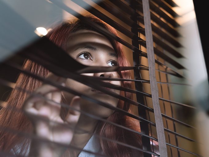 What is agoraphobia - woman peeking through blinds