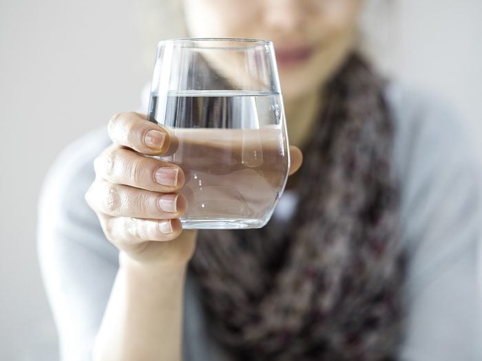 Happy woman raising glass of water