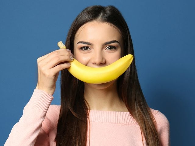 Mood boosting foods - woman with banana smile