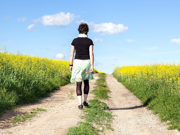 Self-care for caregivers - woman walking in canola field