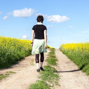 Self-care for caregivers - woman walking in canola field