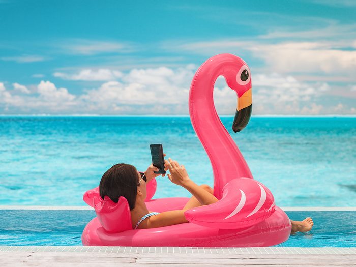 Woman on phone in resort pool