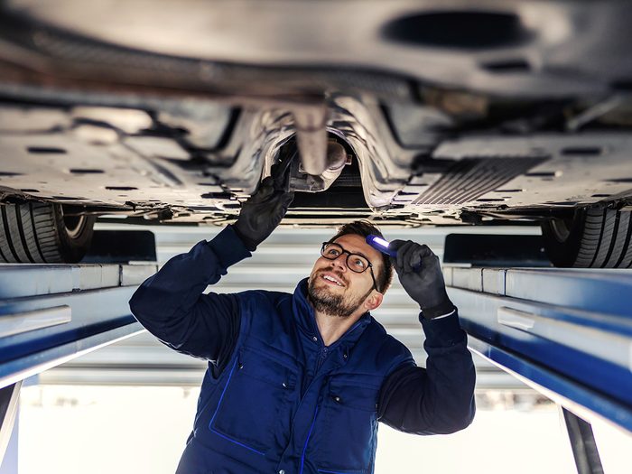 Mechanic inspecting car exhaust system