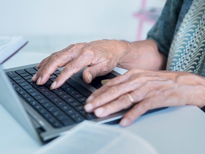 Grandparent scam - senior typing on laptop