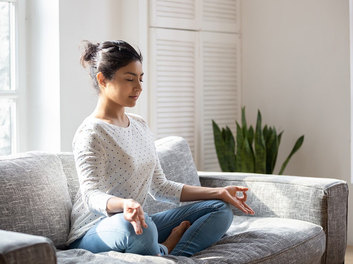 Benefits of anxiety - Woman meditating on couch