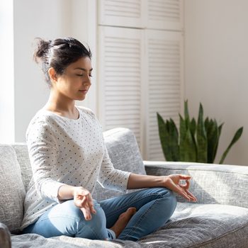 Benefits of anxiety - Woman meditating on couch