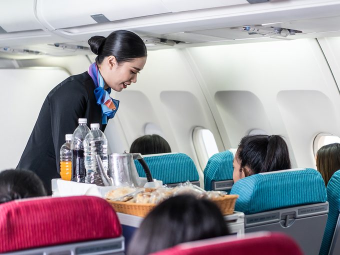 Flight attendant with drink cart