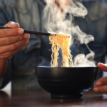 Origin Of Ramen - Man eating ramen noodles with chopsticks