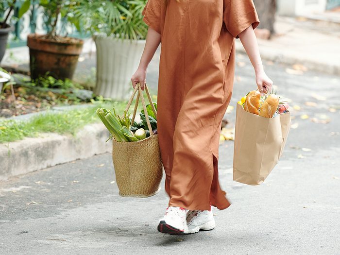 Yiddish Words - Schlep - Person carrying two grocery bags 