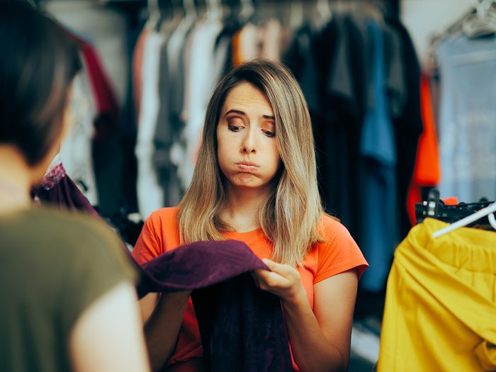 Yiddish Words - Schlock - Unsatisfied woman looking at clothing item 