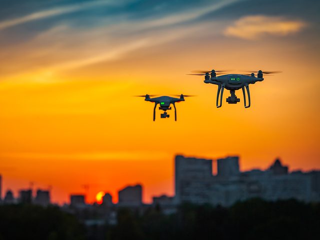 Two drones against sunset sky