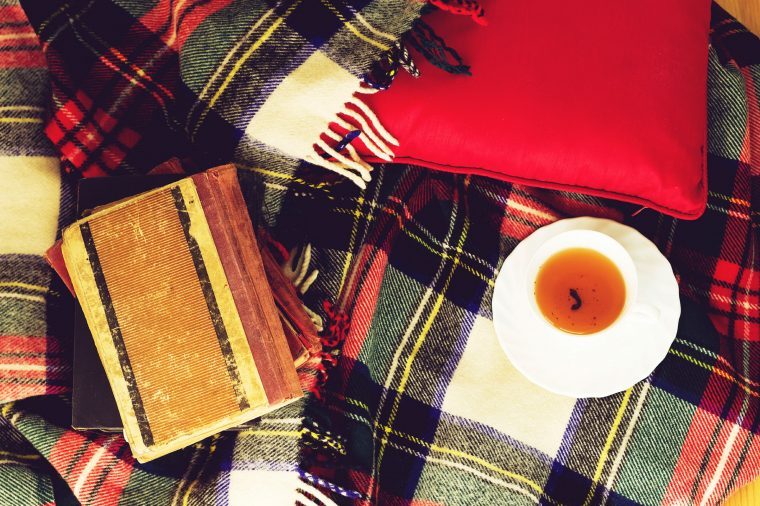 Plaid blanket with a cup of tea and notebook